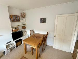 a dining room with a wooden table and a television at Cosy boutique apartment in colourful Bristol in Bristol
