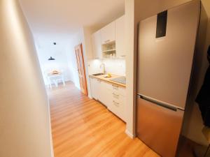 a kitchen with a refrigerator and a wooden floor at Ferienwohnung Hammer - Alpenblick in Siegsdorf