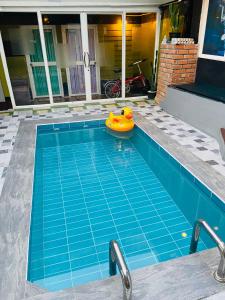 Pakor Boutique Resort في فانجنجا: مسبح فيه بط مطاطي قابل للنفخ