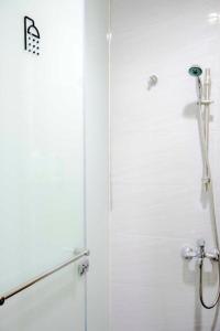 a bathroom with a shower stall and a white wall at Old Door Hostel & Bar in Taipei