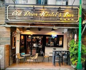 un ristorante con sedie e tavoli di fronte di Old Door Hostel & Bar a Taipei