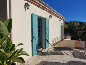 ein weißes Haus mit blauen Fensterläden auf einer Terrasse in der Unterkunft Villa Moana in Èze