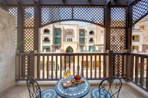 ドバイにあるDurrani Homes - Souk Al Bahar Living Besides Burj khalifa & Fountainの建物の景色を望むバルコニー(テーブル、椅子付)