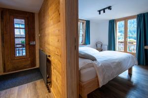 um quarto com uma cama e uma parede de madeira em La Bergère em Ayer