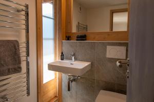 a bathroom with a sink and a toilet and a mirror at La Bergère in Ayer