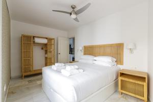 a bedroom with a large white bed with towels on it at Caleta Homes - Apartamentos Pompidou in Málaga