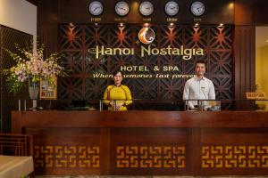 two women standing behind a counter in a restaurant at Hanoi Nostalgia Hotel & Spa in Hanoi