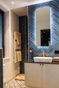 a bathroom with a sink and a mirror at La Garçonnière Genval in Rixensart