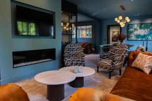 a living room with a couch and chairs and a fireplace at La Garçonnière Genval in Rixensart
