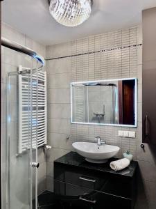 W łazience znajduje się umywalka i lustro. w obiekcie Trevilles Apartamenty Londyn w Szklarskiej Porębie