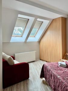 sypialnia na poddaszu z łóżkiem i świetlikami w obiekcie Trevilles Apartamenty Londyn w Szklarskiej Porębie