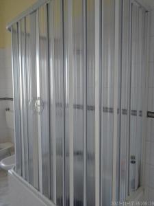 una doccia con porte in vetro in bagno di Antica Masseria Pellegrini a Boscoreale