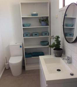 a bathroom with a toilet and a sink and a mirror at Cozy Home Style Accommodation in Marong