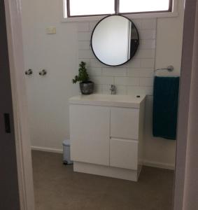 a bathroom with a sink and a mirror at Cozy Home Style Accommodation in Marong