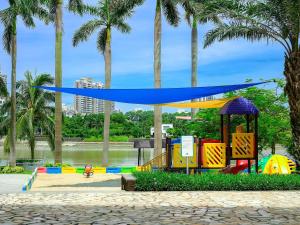 um parque infantil num parque com palmeiras em Pullman Haikou em Haikou