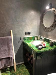uma casa de banho com um lavatório verde e um espelho em RIAD HAWWA JANNA - Privatif em Marrakech