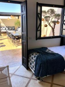 um quarto com uma cama e uma grande janela em RIAD HAWWA JANNA - Privatif em Marrakech