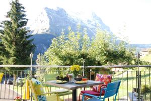 a table and chairs on a balcony with a mountain at Hotel Lauberhorn - Home for Outdoor Activities in Grindelwald