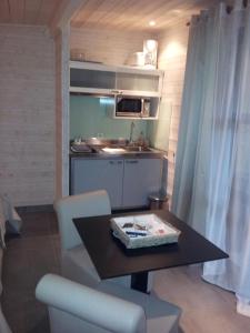 a small kitchen with a table and chairs in a room at Timazen Lodges Agen Sud in Aubiac