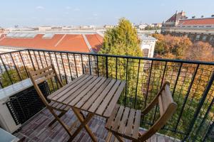 drewniana ławka i dwa krzesła na balkonie w obiekcie dFive River View Apartment w Budapeszcie