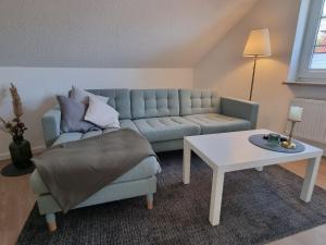 uma sala de estar com um sofá e uma mesa em Ferienwohnung am Springerhof em Schönefeld