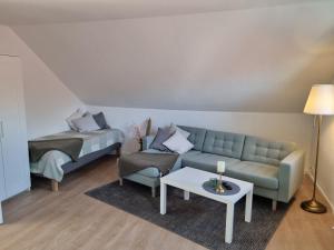 uma sala de estar com um sofá e uma cama em Ferienwohnung am Springerhof em Schönefeld