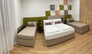 twee bedden en een bank in een kamer bij House of Bruno Apartments - Only self check-in in Trento