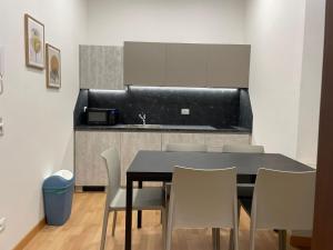 een eettafel met stoelen en een keuken bij House of Bruno Apartments - Only self check-in in Trento