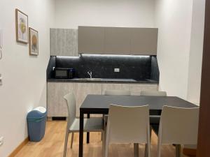 a dining room table with chairs and a kitchen at House of Bruno Apartments - NO Reception in Trento