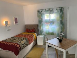a bedroom with a bed and a table and a window at Appartement für Monteure 18qm in Weiterstadt