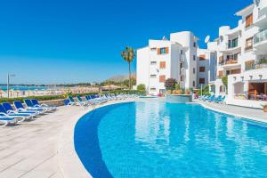 a swimming pool in front of some buildings at Apartment Rovelló - Port d'Alcúdia in Port d'Alcudia