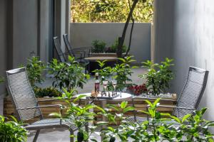 a patio with two chairs and a table with plants at Kipos Boutique Suites in Heraklio Town