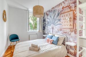sypialnia z dużym łóżkiem z niebieskim krzesłem w obiekcie Ambiance Jungle et Cocon en hyper centre pour 2, 4 ou 6 pers - MyLittleStay w Rouen