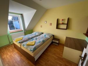 a bedroom with a bed with yellow pillows on it at Apartments Ubytování U Zemanů in Chrášťany