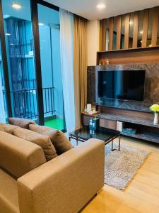 sala de estar con 2 sofás y TV grande en A2 at Forest Khaoyai, en Ban Huai Sok Noi