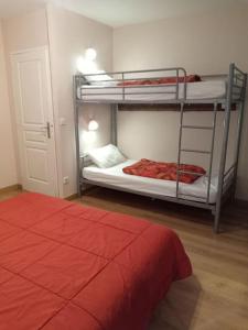 sypialnia z 2 łóżkami piętrowymi i czerwonym łóżkiem w obiekcie Résidence Gascogne, Appartement Rose Boréal w mieście Eaux-Bonnes