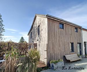 un pequeño edificio de madera con un banco al lado en Holiday home le Lurçon et la Lurcette, en Libin