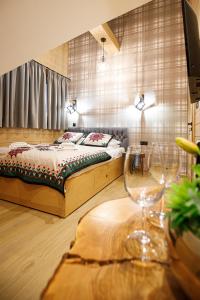 ein Schlafzimmer mit einem Bett und zwei Weingläsern auf dem Tisch in der Unterkunft WILLA GRG in Zakopane