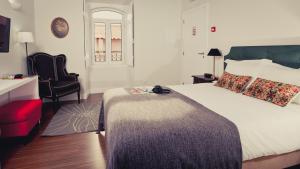 サン・バルトロメウ・デ・メシネスにあるBartholomeu Guesthouseのベッドルーム(大型ベッド1台、椅子付)