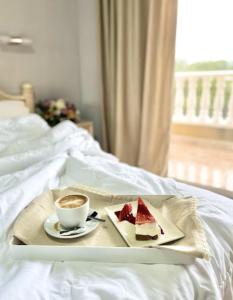 un plato de pastel y una taza de café en una cama en Hotel ParqueMar Premium Beach, en Guardamar del Segura