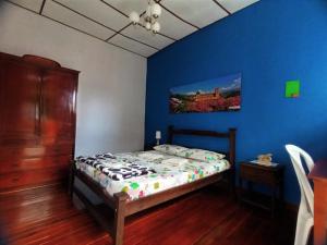 a bedroom with a bed and a blue wall at Caracol Casa Turística in San Gil