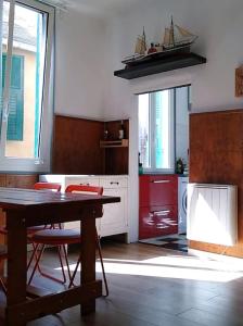 eine Küche mit einem Holztisch und roten Geräten in der Unterkunft Bilocale nel cuore di Genova in Genua