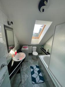a bathroom with a sink and a tub and a toilet at Apartments Ubytování U Zemanů in Chrášťany