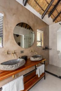 een badkamer met 2 wastafels en een spiegel bij Africa Lodge in Somerset West