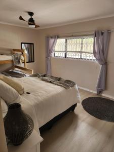 a bedroom with a large bed and a window at 13 at Santos in Mossel Bay