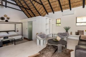 a bedroom with a bed and a couch and a table at Africa Lodge in Somerset West +87 photos