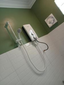 um chuveiro na casa de banho com um telefone na parede em Little Escape Guesthouse Nesat em Phumĭ Chroŭy Svay