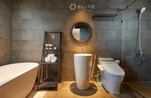 a bathroom with a tub and a toilet and a sink at Elite of the Seas in Ha Long