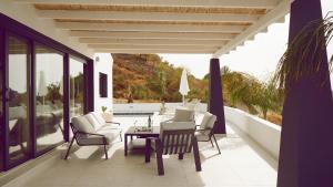 une terrasse avec une table, des chaises et une piscine dans l'établissement Villa Isabella, à Cómpeta