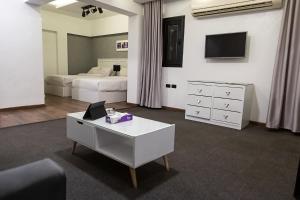 een slaapkamer met 2 bedden, een bureau en een televisie bij Nile Villa Hotel in Caïro